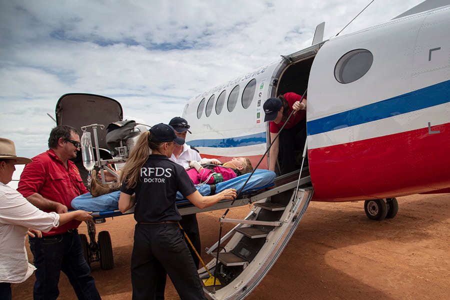 people-stretchering-patient-into-plane -RFDS-charity-qld